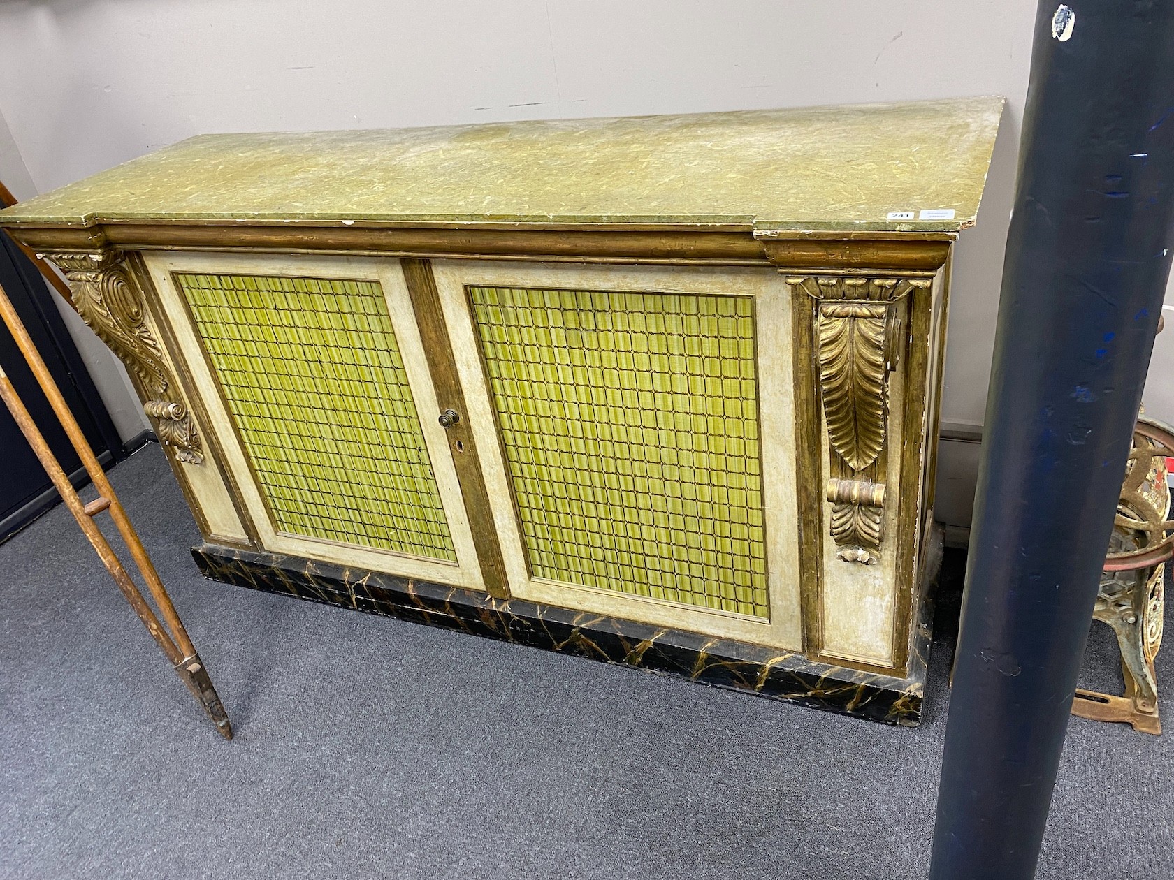 A Regency style cream and giltwood two door cupboard, with a faux green marble top, width 185cm, depth 61cm, height 102cm